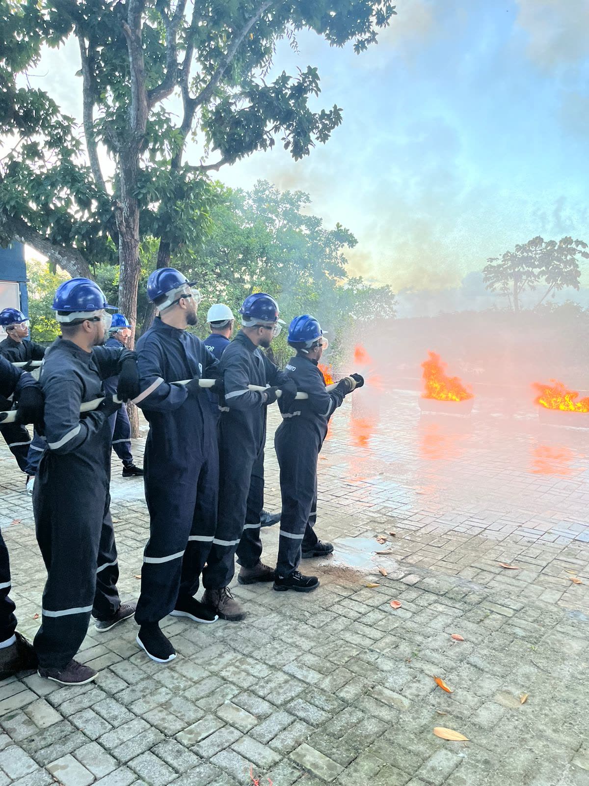 Brigada em linha de fogo real, com mangueira